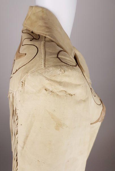 Condition close-up showing pronounced abrasion, surface loss, marks and small cuts across the shoulder and upper sleeve.