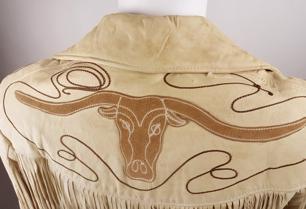 Close-up of the back Western yoke with a tan leather longhorn appliqué and looping brown lariat embroidery.