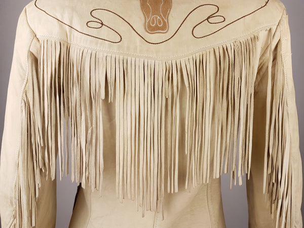 Detailed close-up of the fringing and the upper back with a large appliquéd longhorn head, looping lariat embroidery and a deep fringed yoke.