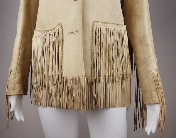 Lower front view of the vintage leather jacket showing two fringed patch pockets, the missing lowest button and fringed hem.