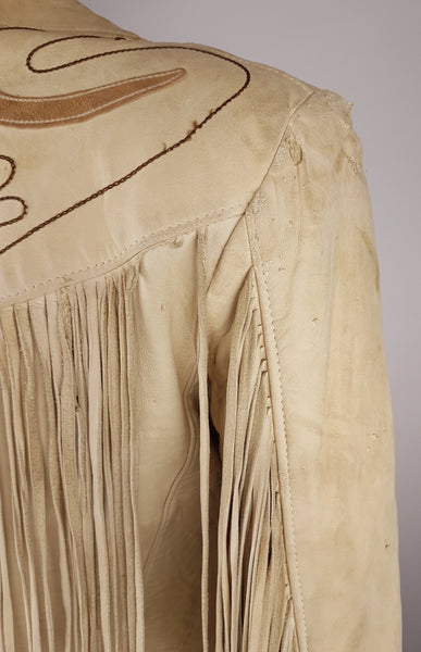 Condition close-up of the rear shoulder showing surface abrasion, small cuts and the seam beneath the fringed Western yoke.