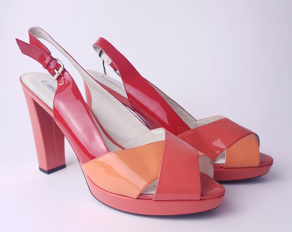 Three-quarter view of unworn Geox Respira colour-block platform sandals in red, coral and peach, with crossover peep toes, block heels and buckled slingback straps.