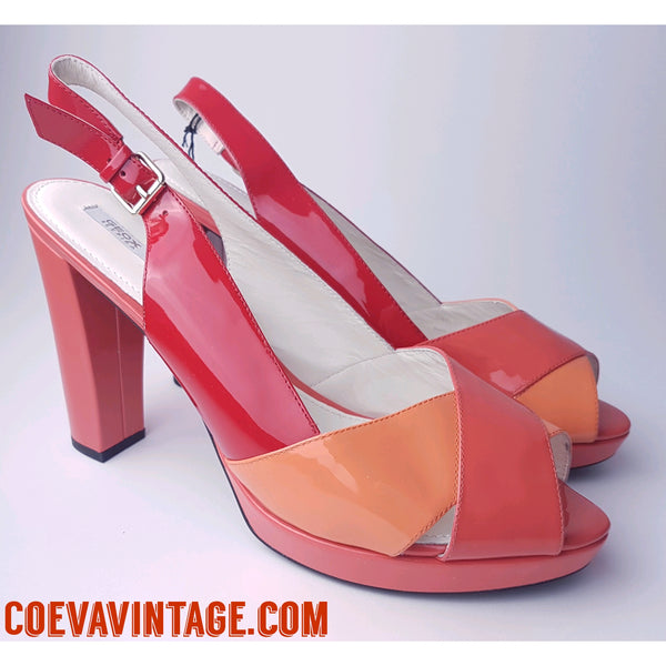 Closeup Three-quarter view of unworn Geox Respira colour-block platform sandals in red, coral and peach, with crossover peep toes, block heels and buckled slingback straps.