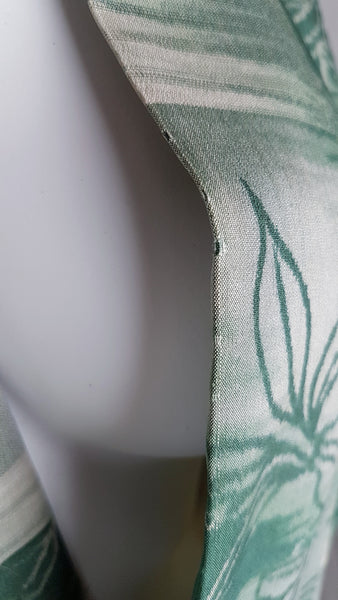 Condition close-up showing a small moth nibble along the edge of the green silk kimono collar.