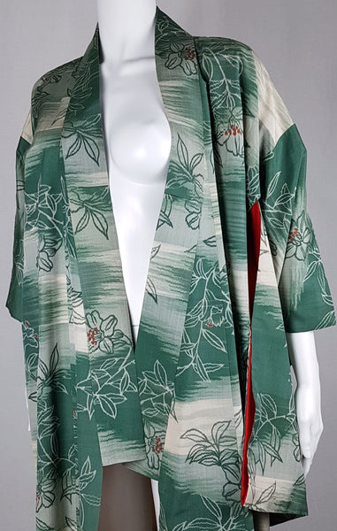 Upper front view of a vintage Japanese silk kimono showing its open neckline, wide collar and green floral pattern.