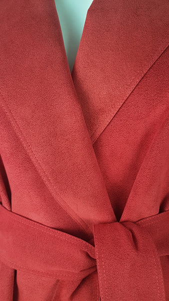 Lapel view of Vintage 1970's Halston Ultra Suede red knee length wrap coat dress with long sleeves, a wide collar, and a matching tie belt on a mannequin 