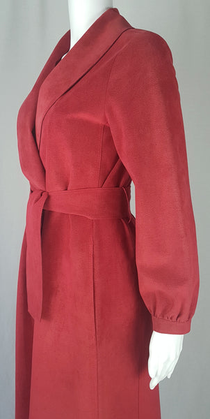 Vintage 1970's Halston Ultra Suede red knee length wrap coat dress with long sleeves, a wide collar, and a matching tie belt on a mannequin 