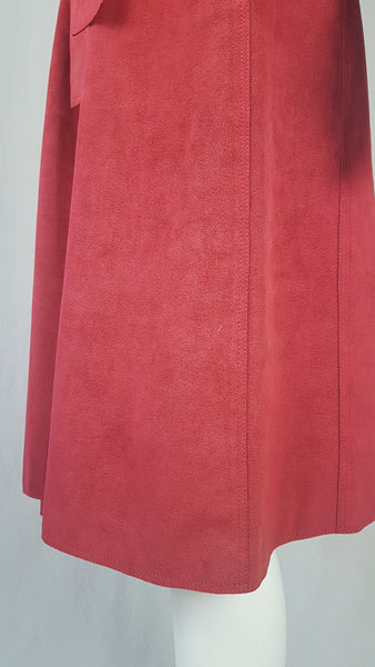 Vintage 1970's Halston Ultra Suede red knee length wrap coat dress with long sleeves, a wide collar, and a matching tie belt on a mannequin 