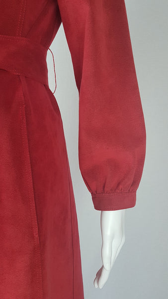 Sleeve view of Vintage 1970's Halston Ultra Suede red knee length wrap coat dress with long sleeves, a wide collar, and a matching tie belt on a mannequin 