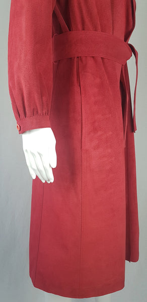 Sleeve and belt view of a Vintage 1970's Halston Ultra Suede red knee length wrap coat dress with long sleeves, a wide collar, and a matching tie belt on a mannequin 