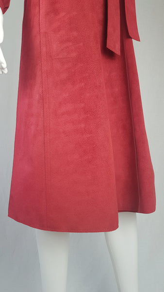 Vintage 1970's Halston Ultra Suede red knee length wrap coat dress with long sleeves, a wide collar, and a matching tie belt on a mannequin 
