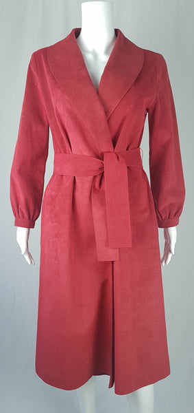 Front view of Vintage 1970's Halston Ultra Suede red knee length wrap coat dress with long sleeves, a wide collar, and a matching tie belt on a mannequin 