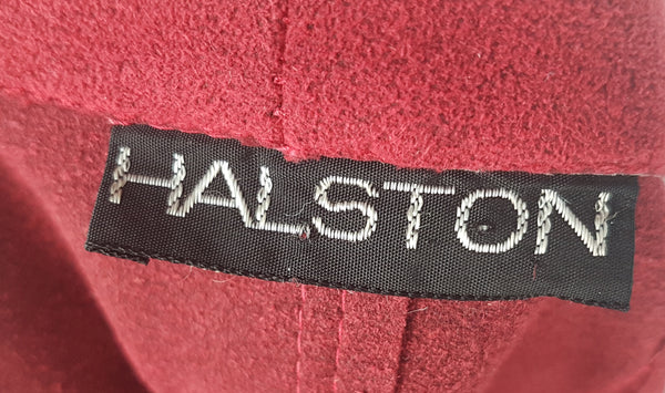 Label view of Vintage 1970's Halston Ultra Suede red knee length wrap coat dress with long sleeves, a wide collar, and a matching tie belt on a mannequin 