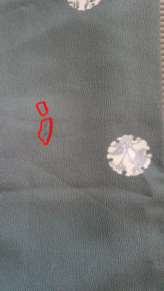 Red circle showing faint stain on Blue grey kimono robe displayed on a mannequin, with wide sleeves, white vertical stripes and white floral medallions - fabric detail