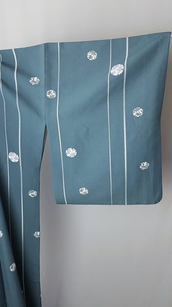 Blue grey kimono robe displayed on a mannequin, with wide sleeves, white vertical stripes and white floral medallions - sleeve view