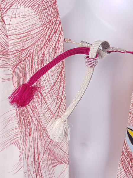 Closeup of tie closure on Tiny age spots on Vintage 1950s to 1960s Japanese haori on a mannequin, featuring red peacock feather motifs with blue, yellow, black and metallic gold details