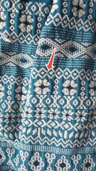 Minor flaws shown with red arrow of a Vintage 1950s Mayan Modern Guatemalan cotton skirt in rich blue and white with traditional geometric woven motifs displayed on a mannequin - detailed motif view