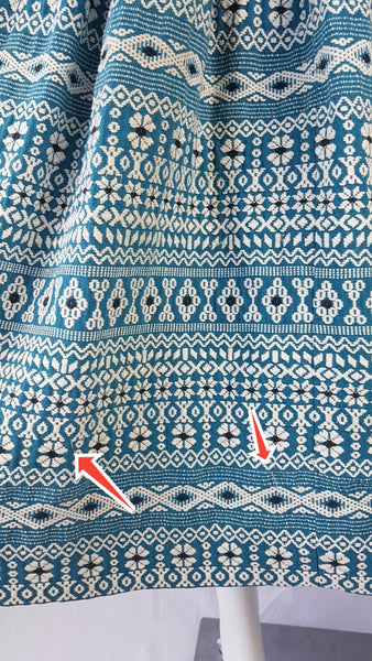 Minor flaws shown with red arrow of a Vintage 1950s Mayan Modern Guatemalan cotton skirt in rich blue and white with traditional geometric woven motifs displayed on a mannequin - detailed motif view