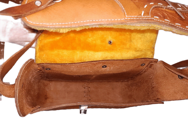 Open view of a vintage Mexican leather saddle purse, showing the clean interior and golden faux-shearling underside of the flap.