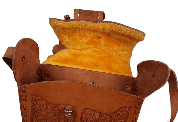 Open view of a vintage Mexican leather saddle purse, showing the clean interior and golden faux-shearling underside of the flap.