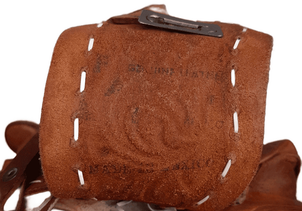 Inner Leather stitching detail view of a vintage Mexican leather saddle purse, showing the clean interior and golden faux-shearling underside of the flap.