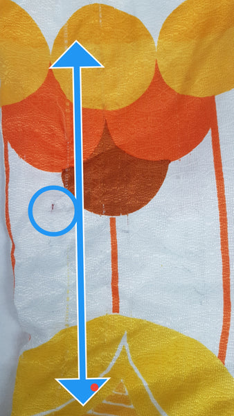 Flaws circled in blue - Vintage 1960s white palazzo jumpsuit on a mannequin with a V-neck and bold orange and yellow abstract print - fabric and print details