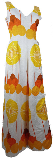 Vintage 1960s white palazzo jumpsuit on a mannequin with a V-neck and bold orange and yellow abstract print - front view