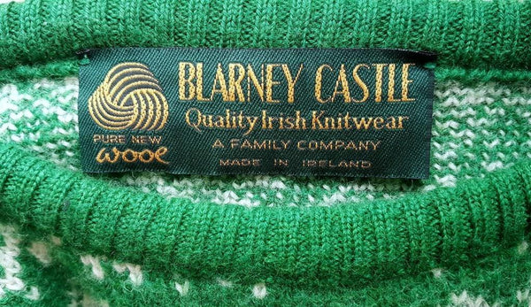 Label for Vintage 1970s - 1980s Blarney Castle Irish fisherman’s green wool sweater with white shamrock and patterns on a mannequin