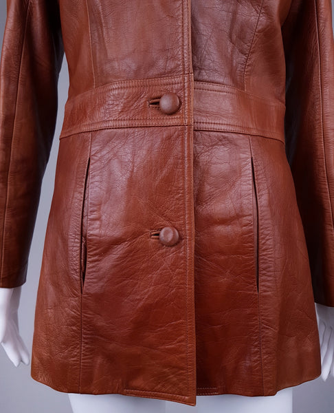 Front waist detail with three leather-covered buttons, vertical welt pockets and curved shaping seams