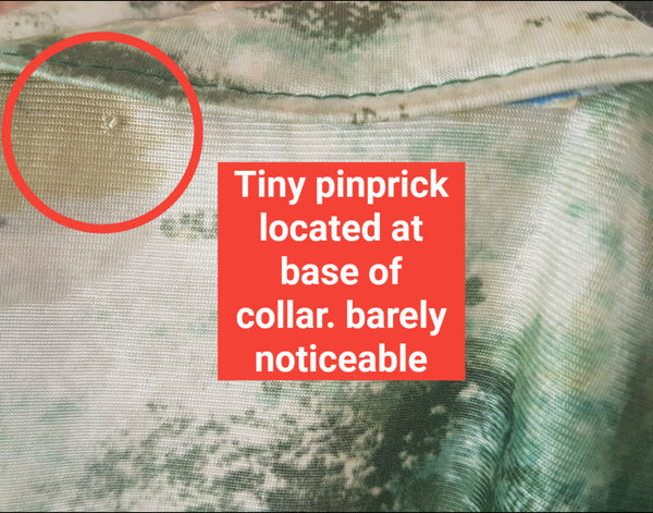 Red circled pinprick flaw on base of collar of Vintage 1970s fitted long sleeve shirt with a pointed collar and green forest landscape print