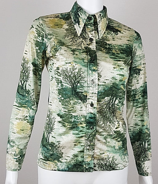Vintage 1970s fitted long sleeve shirt with a pointed collar and green forest landscape print on a mannequin - front view