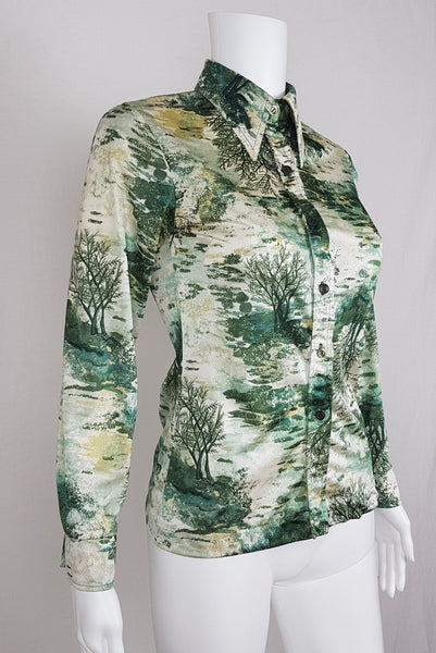 Vintage 1970s fitted long sleeve shirt with a pointed collar and green forest landscape print on a mannequin - front side view