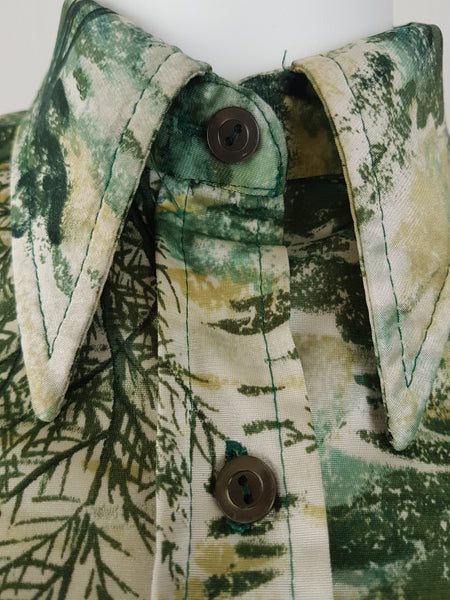 Vintage 1970s fitted long sleeve shirt with a pointed collar and green forest landscape print on a mannequin - collar and buttons view