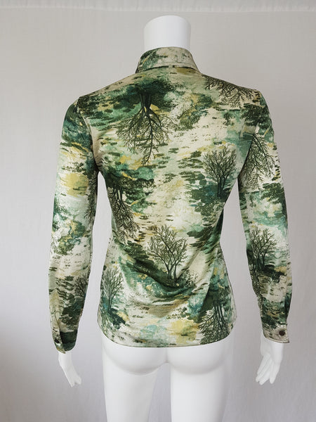 Vintage 1970s fitted long sleeve shirt with a pointed collar and green forest landscape print on a mannequin - back view
