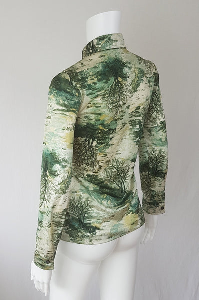 Vintage 1970s fitted long sleeve shirt with a pointed collar and green forest landscape print on a mannequin - back side view