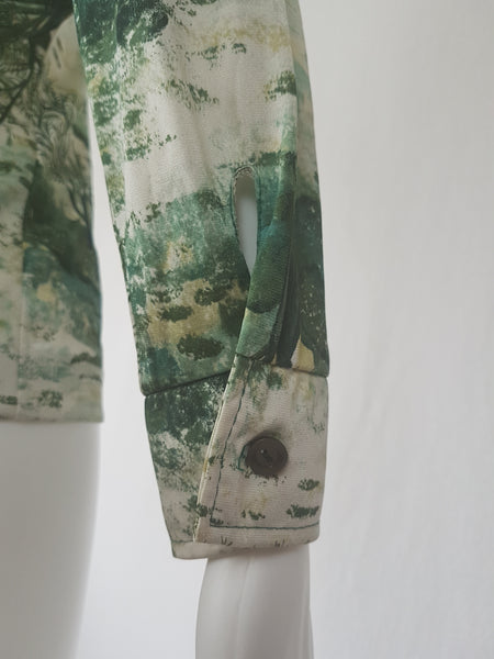 Vintage 1970s fitted long sleeve shirt with a pointed collar and green forest landscape print on a mannequin - sleeve view