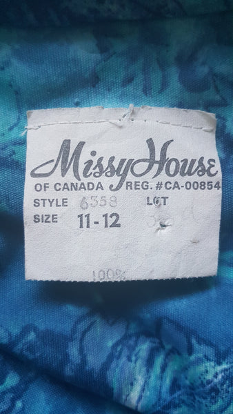 Label of Vintage 1970s Missy House of Canada maxi dress with an aqua blue patterned bodice, long sleeves, pointed collar, and a white skirt with coordinating abstract panels shown on a mannequin