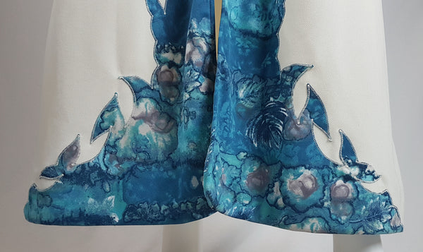 Vintage 1970s Missy House of Canada maxi dress with an aqua blue patterned bodice, long sleeves, pointed collar, and a white skirt with coordinating abstract panels shown on a mannequin