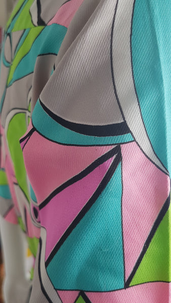 Closeup of fabric print on Vintage 1980s Lady Bayard shirt dress with short sleeves, a pointed collar, button front, matching tie belt, and a bold abstract geometric print in pink, turquoise, lime green, grey, and black displayed on a mannequin