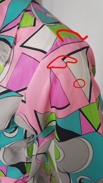Closeup with Red circled flaws on shoulder of Vintage 1980s Lady Bayard shirt dress with short sleeves, a pointed collar, button front, matching tie belt, and a bold abstract geometric print in pink, turquoise, lime green, grey, and black displayed on a mannequin
