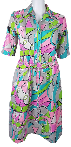 Vintage 1980s Lady Bayard shirt dress with short sleeves, a pointed collar, button front, matching tie belt, and a bold abstract geometric print in pink, turquoise, lime green, grey, and black displayed on a mannequin