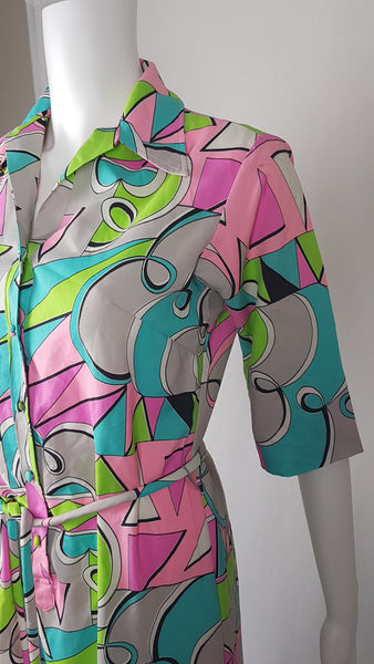 Sleeve, tie belt and upper view of Front view of Vintage 1980s Lady Bayard shirt dress with short sleeves, a pointed collar, button front, matching tie belt, and a bold abstract geometric print in pink, turquoise, lime green, grey, and black displayed on a mannequin
