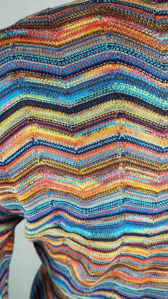 Detailed view of the fine-gauge chevron knit in shades of red, blue, turquoise, coral, orange, yellow, brown and black on a vintage 1990s Holt Renfrew multicolour faux-wrap knit top 