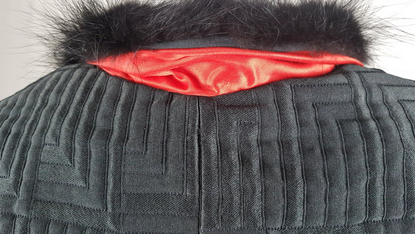 Vintage black brocade cropped bolero jacket with a fur collar, red satin lining, ribbon loop and decorative button displayed on a mannequin - back collar view
