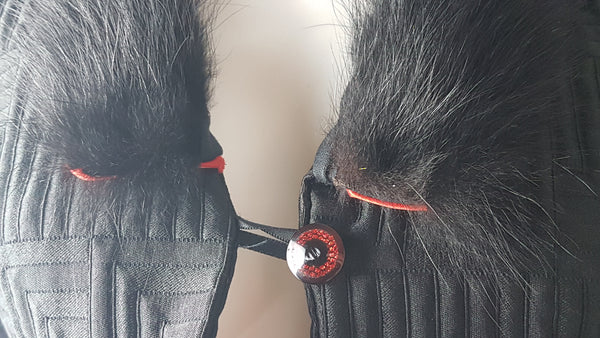 Vintage black brocade cropped bolero jacket with a fur collar, red satin lining, ribbon loop and decorative button displayed on a mannequin - front button closure view