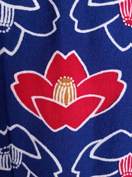 Fabric and print pattern closeup of Vintage hand-stitched full-length Japanese cotton kimono, with a bold blue, red and white lotus flower print 