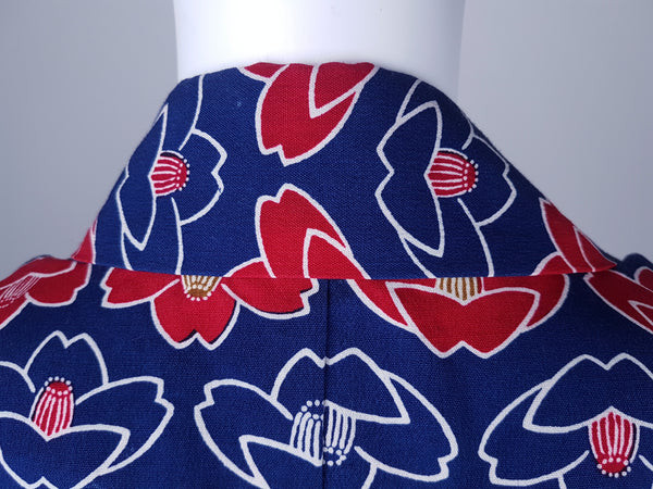 Vintage hand-stitched full-length Japanese cotton kimono displayed on a mannequin, with a bold blue, red and white lotus flower print - Back collar view