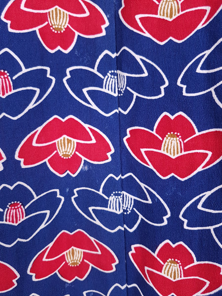 Fabric and print pattern closeup of Vintage hand-stitched full-length Japanese cotton kimono, with a bold blue, red and white lotus flower print - including slight imperfections