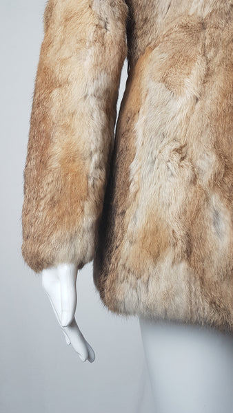Close-up of a vintage late 1980s to early 1990s brown rabbit fur jacket on a mannequin, showing the sleeve and natural tonal variations - front view