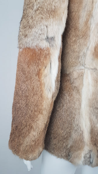 Close-up of a vintage late 1980s to early 1990s brown rabbit fur jacket on a mannequin, showing the sleeve and natural tonal variations - back view